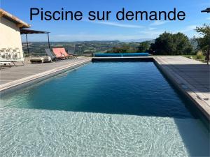 a swimming pool with blue water in front of a house at Gite chez Polo in Les Mételles
