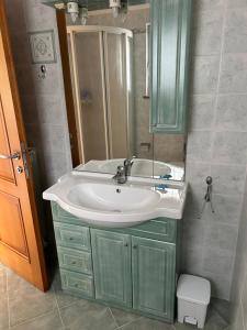 bagno con lavandino e specchio di Ai 2 Olmi - monolocali nel verde a Múggia