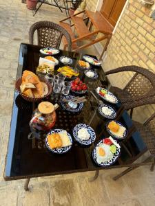 une table recouverte de beaucoup de différents types de nourriture dans l'établissement Hotel Ravshan Boutique, à Boukhara