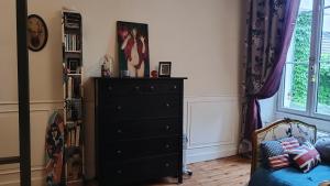 a bedroom with a black dresser and a window at Buky Palace in Pons