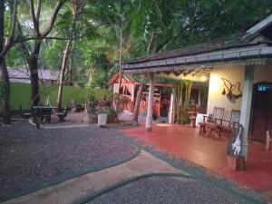 patio budynku ze stołem i ławkami w obiekcie Green Park Safari House w mieście Udawalawe