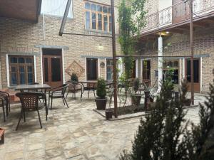 een patio met stoelen en tafels en een gebouw bij Hotel Ravshan Boutique in Bukhara