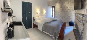 um pequeno quarto com uma cama e uma câmara em Castellorizon Pensione em Meyisti