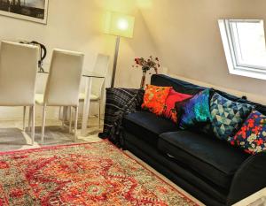 un divano nero con cuscini colorati in soggiorno di Small apartment in the heart of Selsdon! a Addington