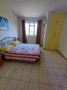 a bedroom with a bed and a yellow cabinet at Villa kartner in Albion