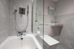 een badkamer met een douche, een bad en een wastafel bij Modern,Bright and spacious 2 bed in Brentwood