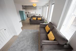 een woonkamer met een bruine leren bank en gele kussens bij Modern,Bright and spacious 2 bed in Brentwood