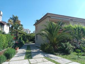 una casa con una palmera al lado de una pasarela en Apartments Orange Lovran en Lovran