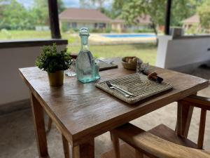 Tanzania Safari Lodge في أروشا: طاولة خشبية مع زجاجة زجاجية وصينية