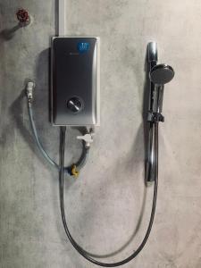 a water hose hooked up to a dispenser on a wall at 3 Retro-Antique Inspired Interconnected Family Rooms at Country Lodge - Eco Valley Retreat 豐之谷 in Tawau