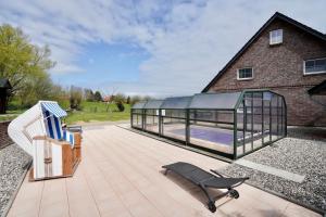 a glass house with a swimming pool in it at Villa Jenny mit Pool in Wohlenhagen +17 photos