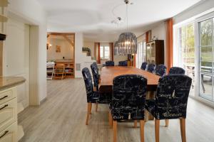 a kitchen and dining room with a wooden table and chairs at Villa Jenny mit Pool in Wohlenberg