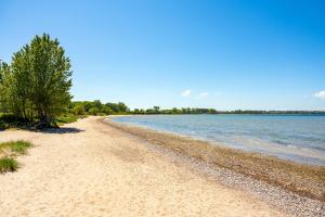 a sandy beach next to a body of water at Villa Jenny mit Pool in Wohlenberg