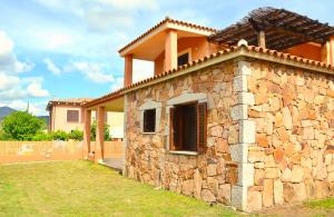 ein Steinhaus mit einer Steinmauer in der Unterkunft ISS Travel, Gli Asfodeli - Large apartments with private terrace in San Teodoro