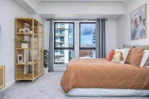 オークランドにあるCBD Studio Getawayのベッドと大きな窓のある寝室 +5枚の写真