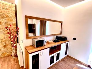 Habitación con espejo y microondas en la encimera. en ILLYRIAN hotel en Ksamil