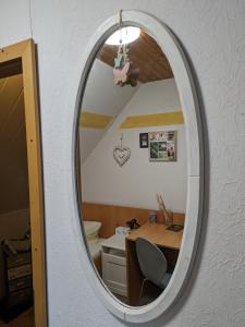 a mirror in a room with a desk and a table at Kuscheliges Mini-Vintage-Zimmer in Felsberg