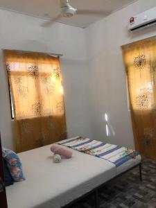 a bed in a room with two windows with curtains at Homestay Idaman B B with 2 room aircond 2 Quen Bed and Not Sharing Room -Privacy in Kuala Terengganu
