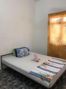 a bed in a room with a white wall at Homestay Idaman B B with 2 room aircond 2 Quen Bed and Not Sharing Room -Privacy in Kuala Terengganu