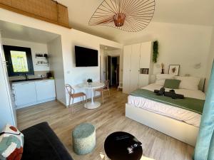 a bedroom with a bed and a kitchen with a table at Studio Vue Mer - Piscine - Porticcio in Porticcio