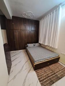 a bedroom with a bed and wooden cabinets at Swaraj Palace in Jaipur