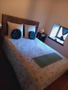 una camera da letto con un letto con due cuscini e uno specchio di La croix des Landes gîte ou chambre d'hôte avec piscine à Chouvigny a Chouvigny