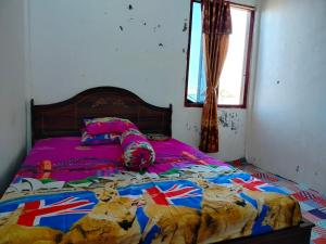 a bedroom with a bed with a bedspread with british flags at Atta Ratu Homestay in Komodo