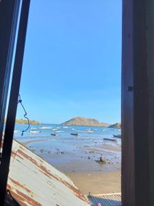 widok na plażę z łodziami w wodzie w obiekcie Atta Ratu Homestay w mieście Komodo