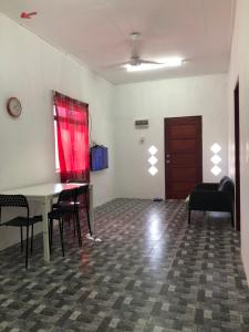 a room with a table and chairs and a red curtain at Homestay Idaman B B with 2 room aircond 2 Quen Bed and Not Sharing Room -Privacy in Kuala Terengganu