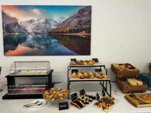 - une table avec plusieurs plateaux de pain et de viennoiseries dans l'établissement Hotel Asterix, à Bolzano