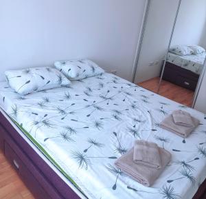a bed with two pillows on it in a bedroom at A l e k a in Radovići