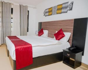 a bedroom with a large bed with red pillows at Boutique Hotel Rwanda in Kigali