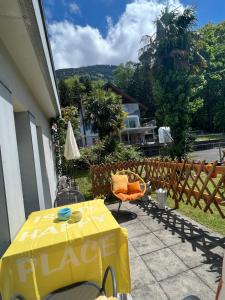 einen Tisch mit einem gelben Tischtuch auf einer Terrasse in der Unterkunft Wohnung „Perla Paradiso“ in Fluelen