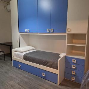 - une chambre avec un lit et des armoires bleues dans l'établissement MBR-Napoli, à Naples