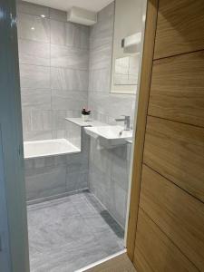een badkamer met een wastafel en een bad bij Bright, spacious 1 bedroom flat in Brentwood