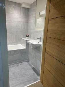 a bathroom with a sink and a bath tub at Bright, spacious 1 bedroom flat in Brentwood