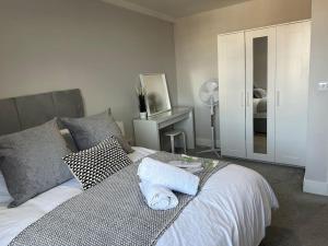 een slaapkamer met een bed met twee handdoeken erop bij Bright, spacious 1 bedroom flat in Brentwood