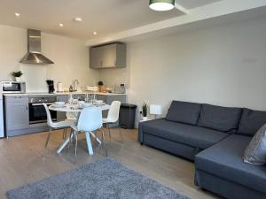 sala de estar con sofá, mesa y sillas en Bright, spacious 1 bedroom flat, en Brentwood