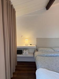 um quarto com duas camas e um candeeiro numa prateleira em Casa do Mar | Sea House | Apúlia em Apúlia