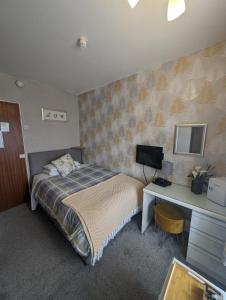 a bedroom with a bed and a desk with a computer at Hesketh Hotel in Blackpool