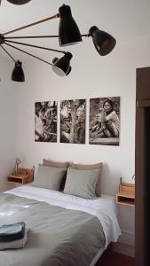 Schlafzimmer mit einem Bett mit Bildern an der Wand in der Unterkunft Le Manivert in Vitry-Laché
