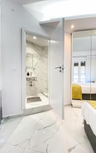 Un dormitorio blanco con una puerta de cristal que conduce a un baño. en Paradise+ With Jacuzzi In the heart of Athens!, en Atenas 47 fotos más