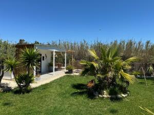 una casa con palme in un cortile di Cabane le Flamant avec jardin, piscine chauffée et parking a Saintes-Maries-de-la-Mer