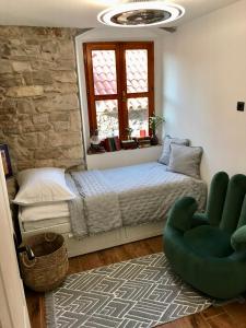 ein Schlafzimmer mit einem Bett und einem grünen Stuhl in der Unterkunft Split Centar Diocletian's Palace in Split