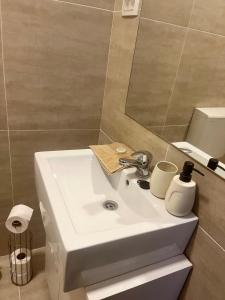 y baño con lavabo blanco y espejo. en CONFORT GuestHouse, en Oradea