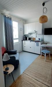 sala de estar con sofá y cocina en Apartment Lintu, en Mikkeli