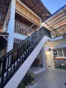 a white house with a staircase in front of it at Sunny Terrace in Baler