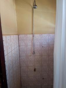 a bathroom with a pink tiled wall with a shower at NIGHT ROCKS SUITS in Jinja