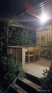 a table and chairs on a porch at night at Bitez Tiny House & Beach in Bodrum City