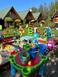 a bunch of childrens play equipment in a yard at Domki letniskowe Katarzyna in Sarbinowo